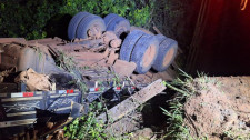 Caminhão com 15 toneladas de mandioca cai em córrego durante travessia em ponte de madeira